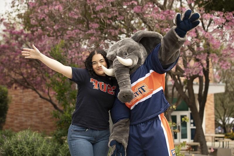 Student posing with Tuffy the school mascot